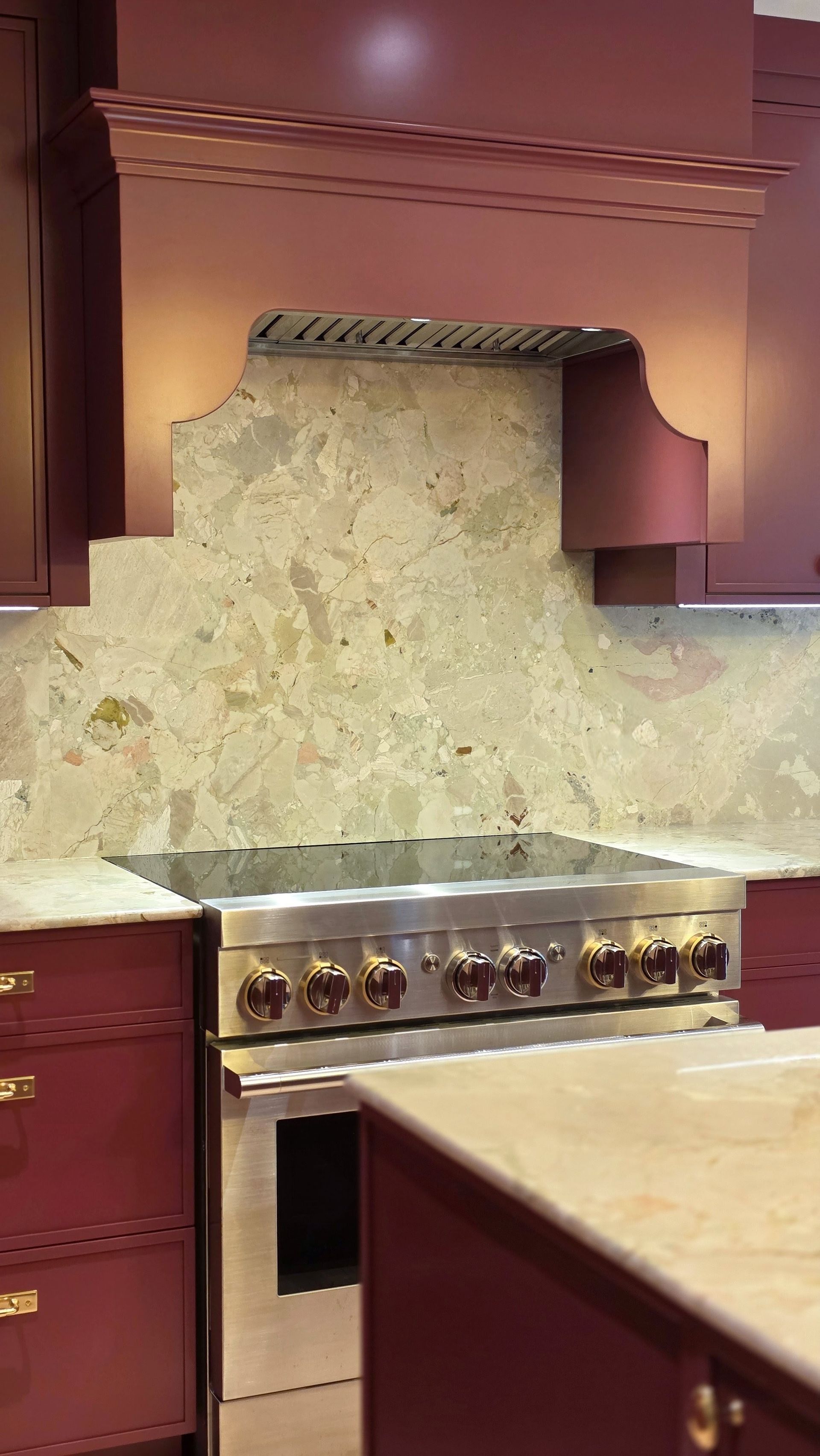 Burgundy kitchen cabinets with warm wood and brass — red kitchen renovation by Corey Bowen Construction